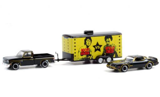 Modelauto Chevrolet C-10 Pickup Custom Deluxe zwart/gold 1981 met 1979 Pontiac Firebird Trans Am en Zweiachskofferanh&Atilde;&curren;nger Rocky II 1/64 Greenlight