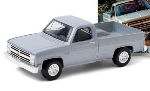 Modelauto Chevrolet Silverado pickup metallic grijs 1985 1/64 Greenlight